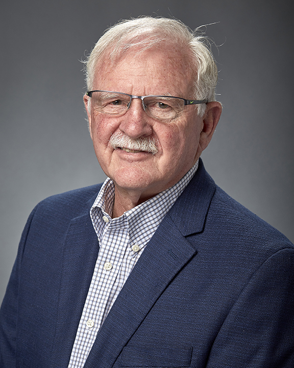Al Cunningham photp man in a blue jacket wearing eye glasses